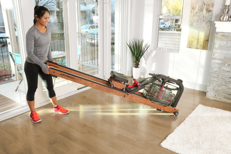 Image of a female moving a Life Fitness HX Rower, using the transport wheels at the front of the machine. Fitness Options, Online Gym Equipment Supplier and Nottinghamshire Showroom