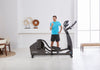 Image showing a male standing at the side of a Life Fitness E5 cross trainer whilst looking at his mobile phone.  Fitness Options. Nottingham's leading fitness & gym equipment supplier.